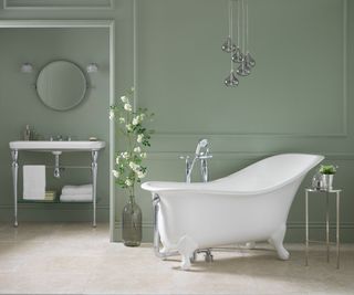 white slipper bath in green bathroom