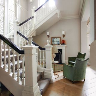Seating area and fireplace at the bottom of a grand staircase