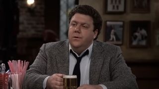 George Wendt's Norm holding beer at Cheers bar