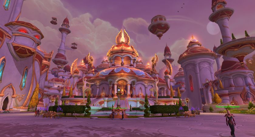 A screenshot of the World of Warcraft: Midnight alpha. A wide shot of Silvermoon City, the golden elven city. A beaming building sits in the middle, surrounded by bushes and a glowing pool.