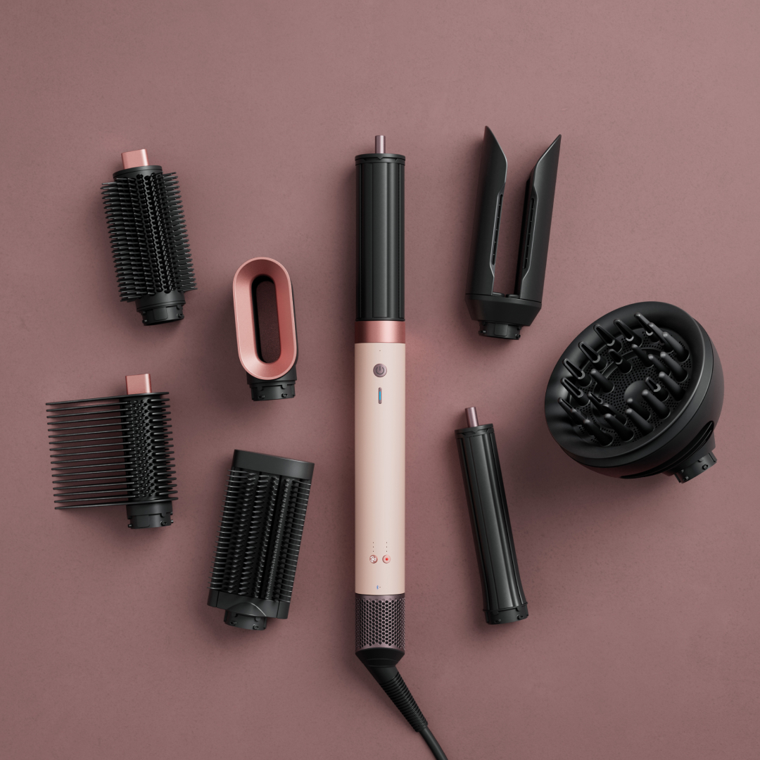 Dyson airwrap coanda 2x and attachments on pink gradient background 