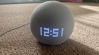 Amazon Echo Dot with clock on surface in a home