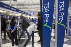 Passengers walk through the entrance of a TSA PreCheck