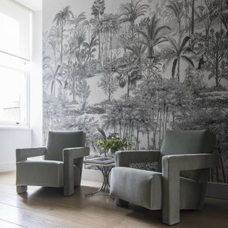 Kitchen with monochrome jungle wall mural and pair of chairs covered in cotton velvet