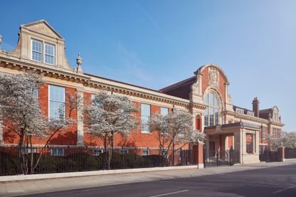 Exterior of Ladbroke Hall with brick facade and trees in blooms