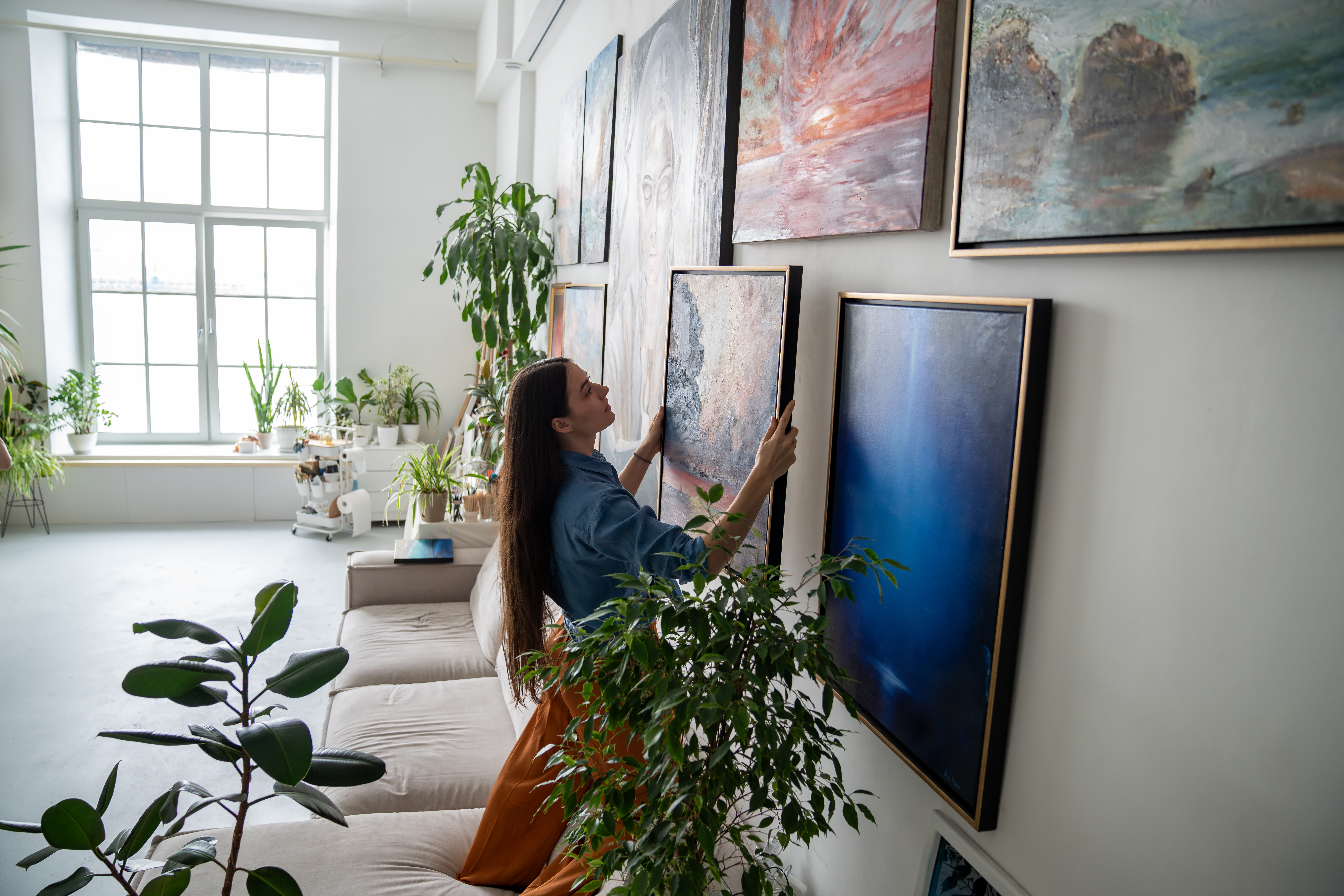 Woman hanging artwork on wall