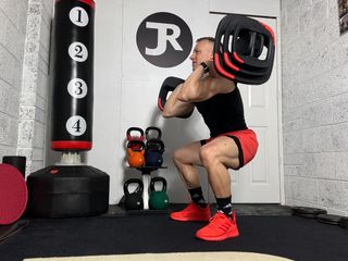 Les Mills trainer Justin Riley demonstrating a front rack squat