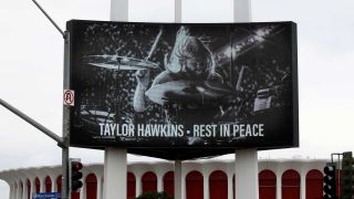 A video screen commemorating Taylor Hawkins outside the Kia Forum in Los Angeles
