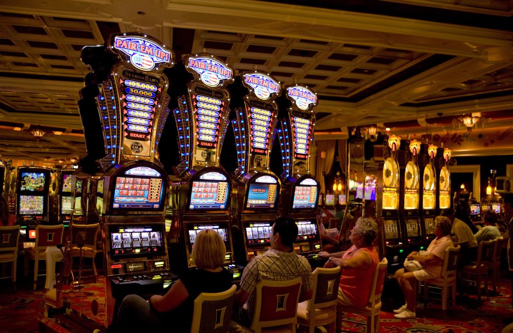 People sitting at Pair 'Em Up slot machines at the Wynn Hotel and Casino in Las Vegas, Nevada