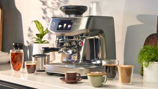 Breville Oracle Jet next to five of its pre-set coffee drink options