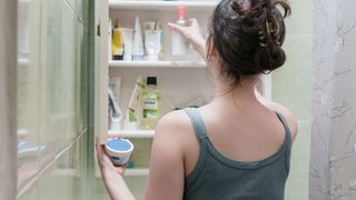 Woman reaching into her makeup cabinet