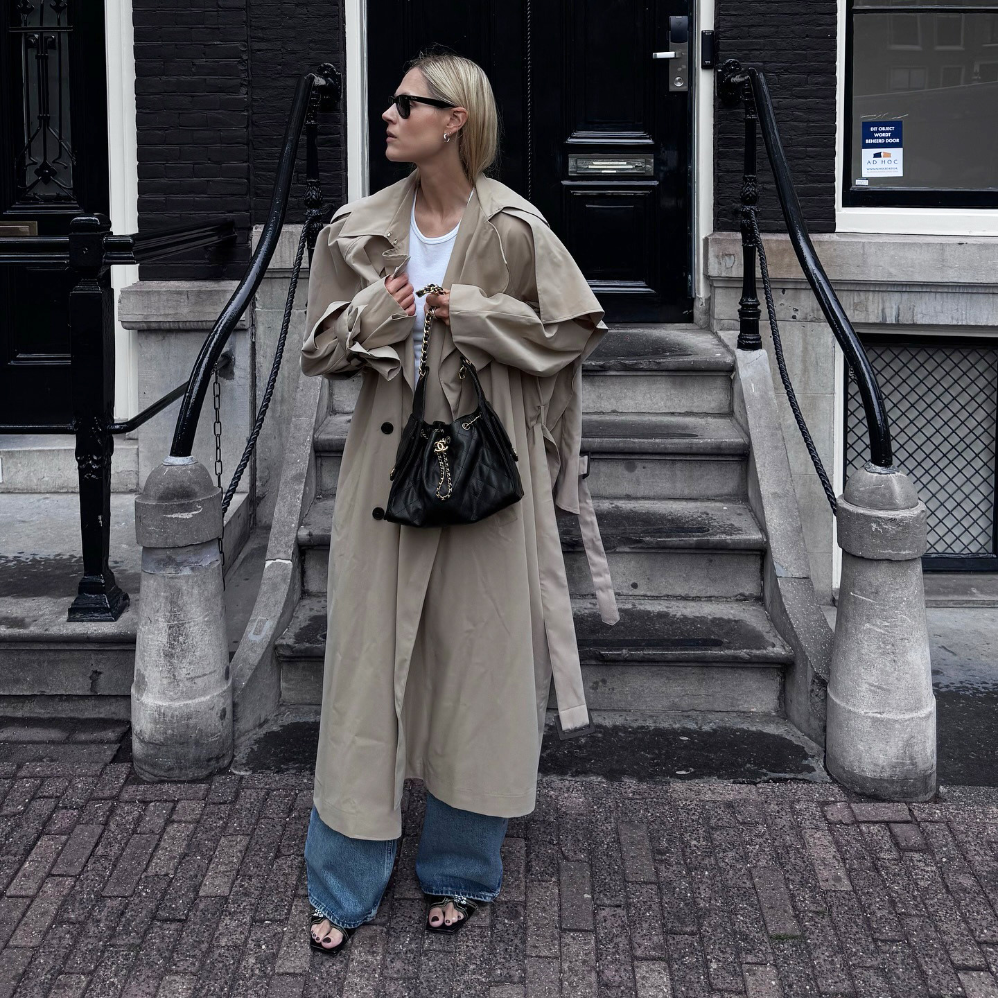 Woman wearing a trench coat and holding a black leather bag