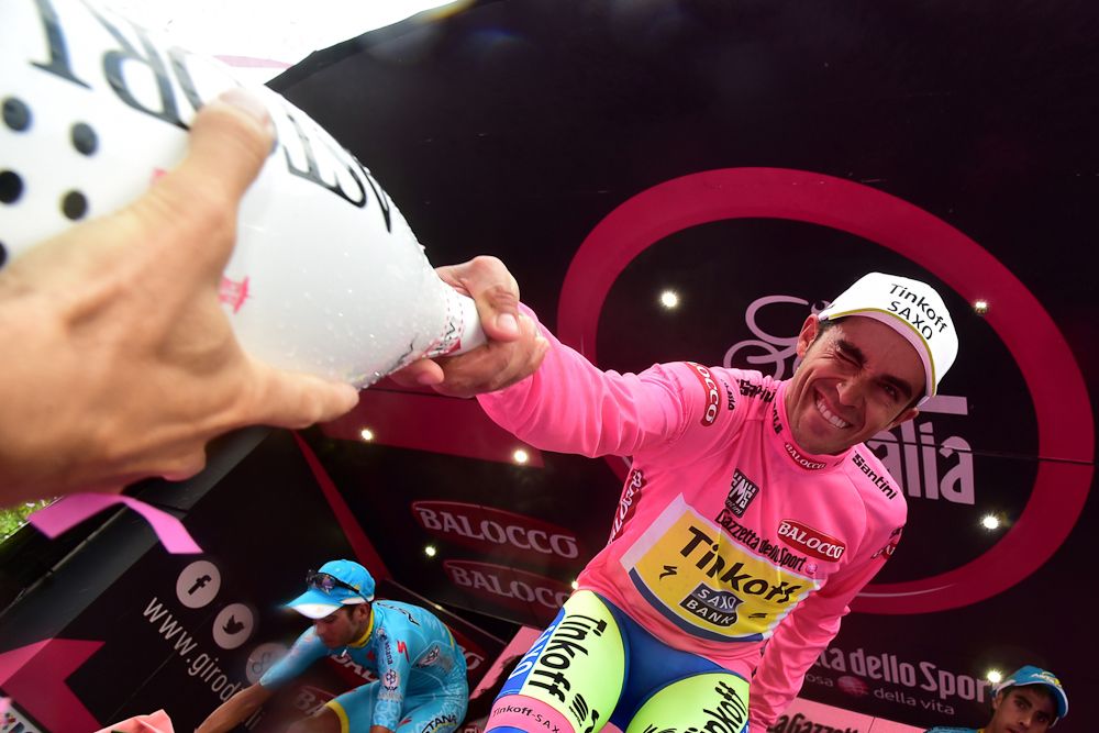 Alberto Contador hands off a bottle of prosecco.