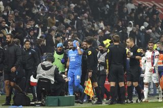 Marseille’s Dimitri Payet leaves the pitch after being hit by a bottle