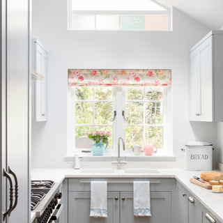 Open plan kitchen with oak parquet floor, light blue fitted cabinets and dining area with French doors. A five bedroom semi detached Edwardian house in South West London, home of Louise and James Steen and their three children.