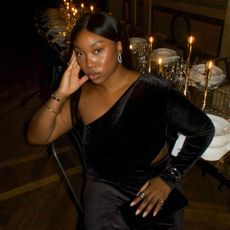 An image of @nnennaechem wearing a black, one-shoulder dress, an example of a perfect autumn wedding guest dress.