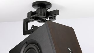 The IsoAcoustics V120 mount holds a speaker in place from a ceiling. 