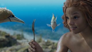 Halle Bailey as Ariel under water with a fork in The Little Mermaid