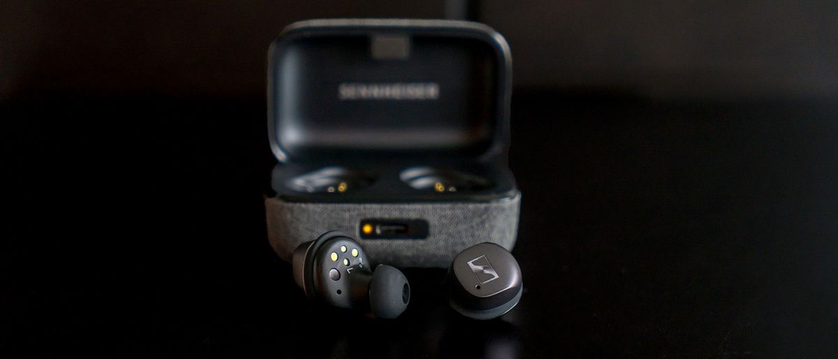 Sennheiser Momentum True Wireless 3 earbuds in front of their case.