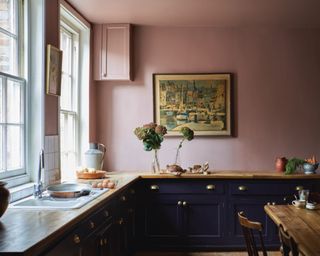 kitchen with black cabinets and earthy pink walls and wooden countertops