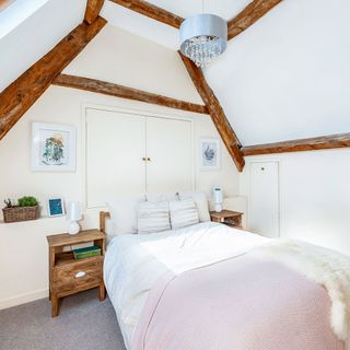 attic bedroom with white walls and wooden side table