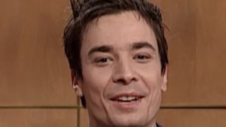 Jimmy Fallon smiling at the Weekend Update desk on SNL