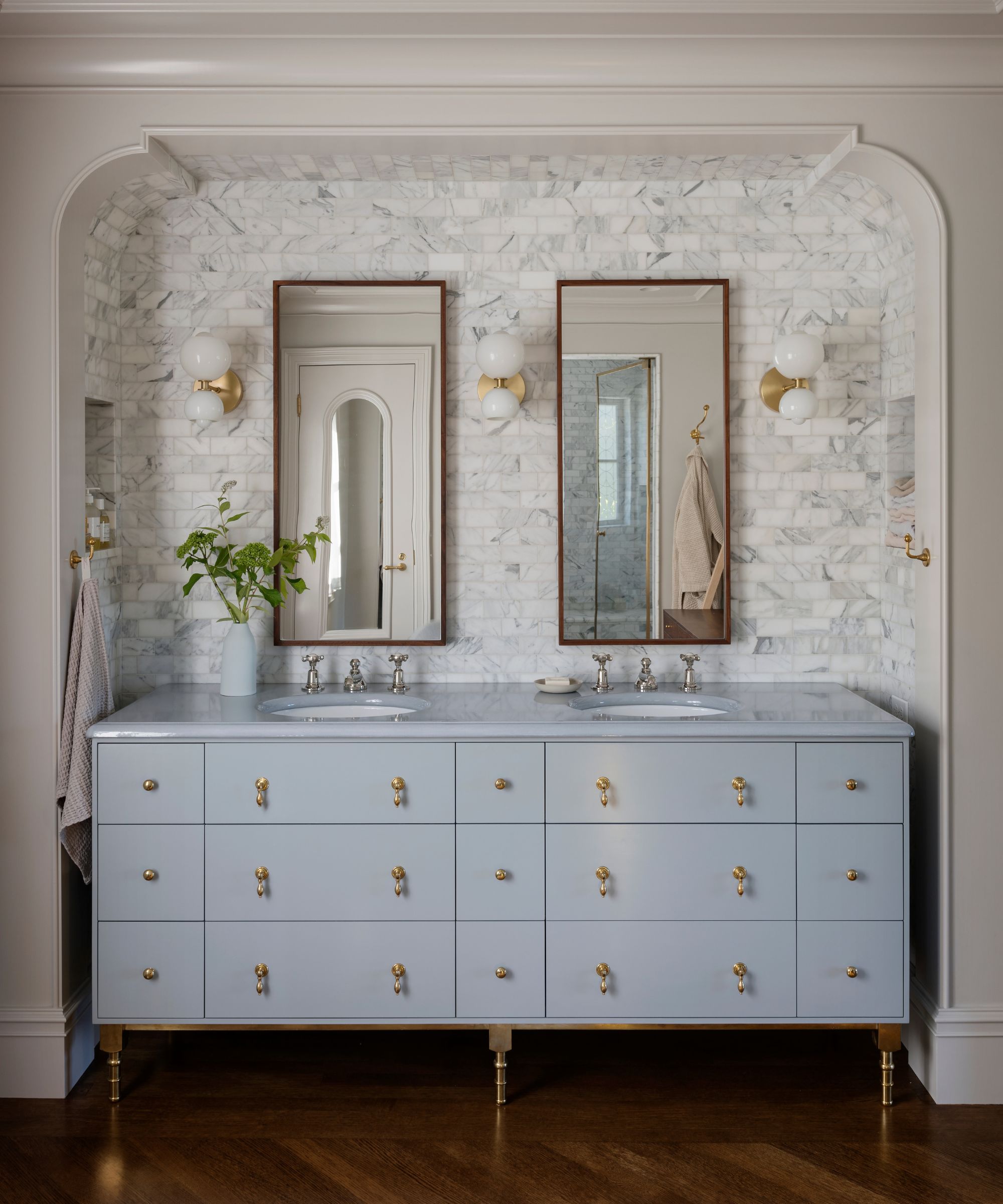 A bathroom with a powder blue vanity with transitional decor.