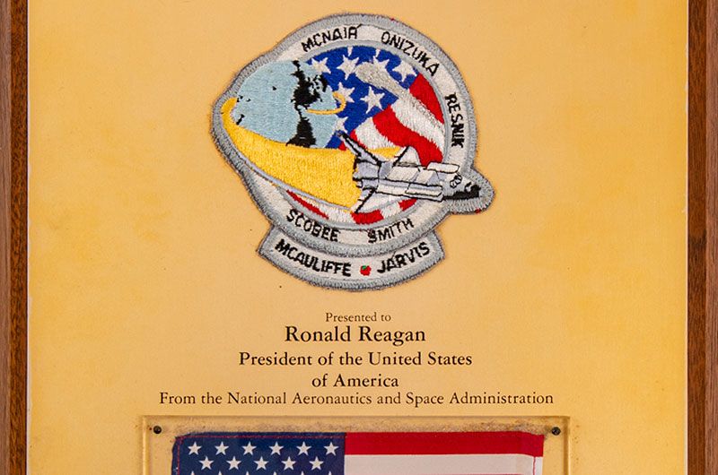 An STS-51L crew patch and American flag recovered from among the debris of the space shuttle Challenger in 1986 were prepared by NASA for presentation to President Ronald Reagan but instead ended up in the collection of a liaison to the White House.