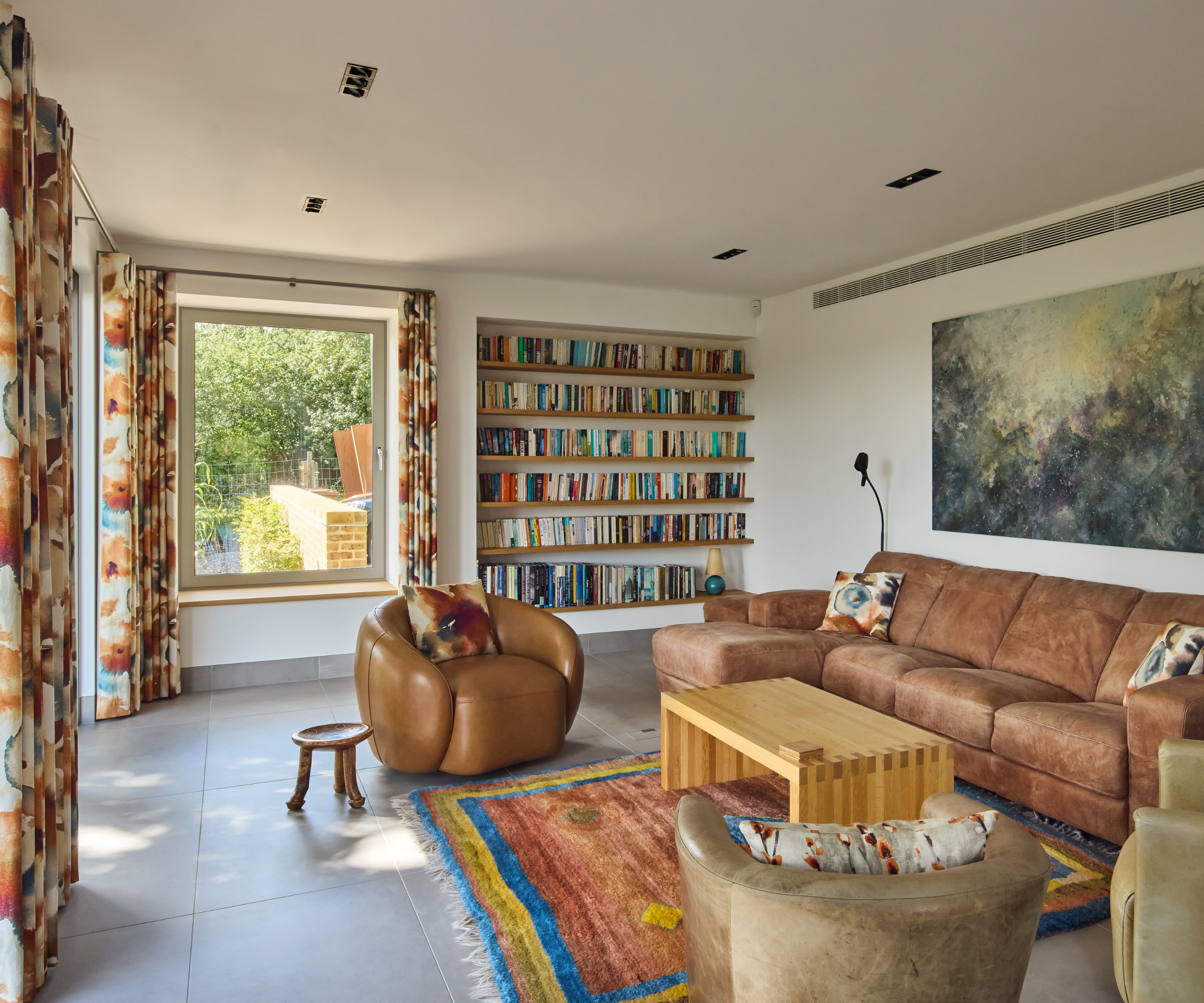 Living room with brown furnishings and square window on back wall to the left side