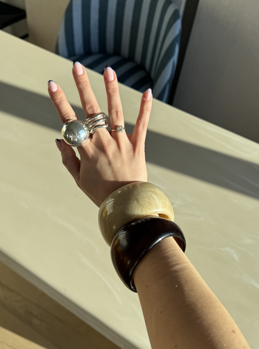 April Lockhart wearing a ring stack with two bangle bracelets