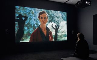 A woman watching theatre performance on screen