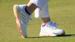 The stunning Adidas Codechaos Women's Golf Shoe walking the course in an excellent pink and white colorway