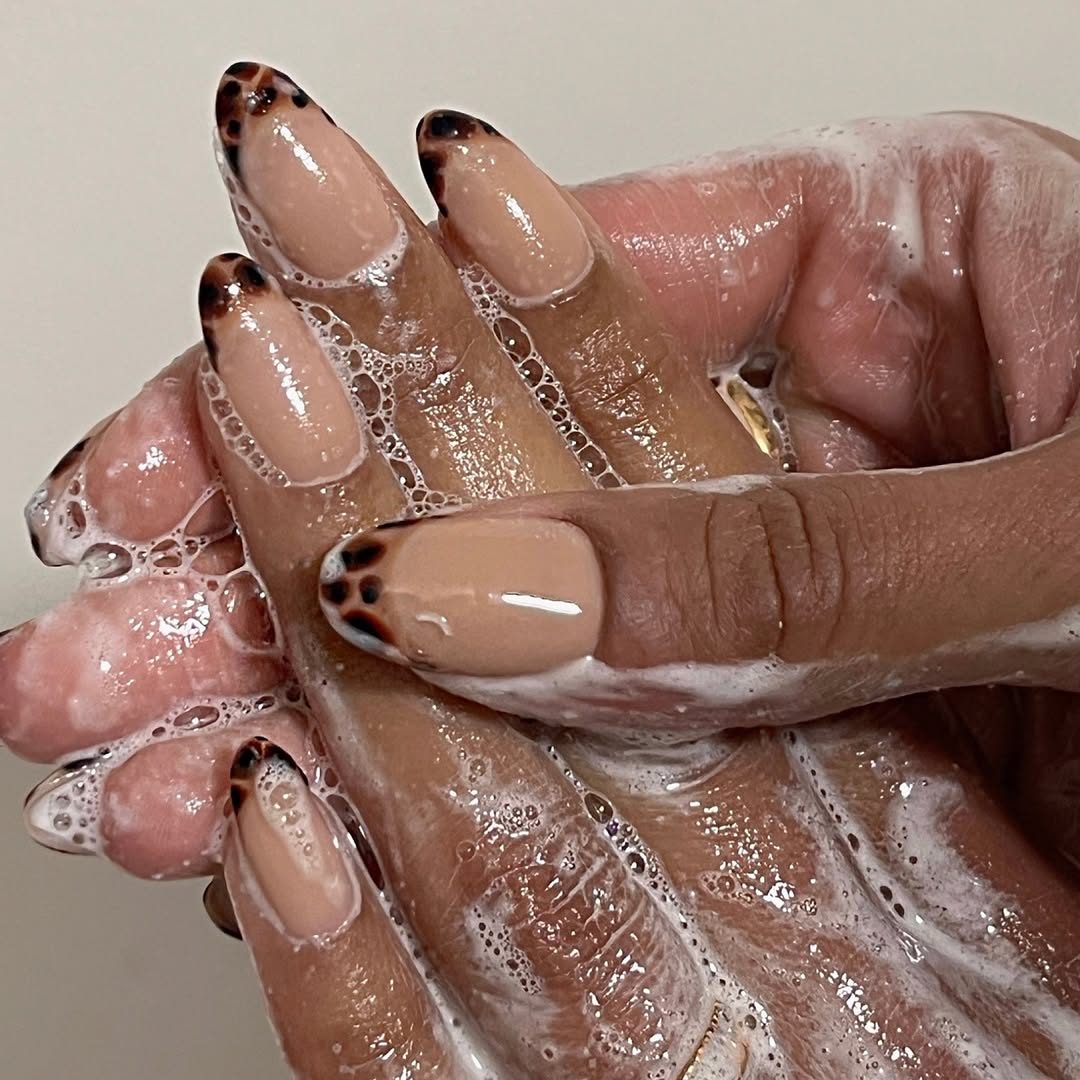 a person wearing a french manicure with tortoise shell tips