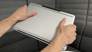 Someone holding up the Surface Laptop Studio, showing the bottom of the laptop.