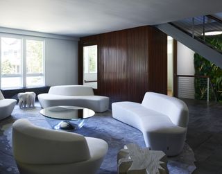 white sculptural sofas on a irregular dark grey rug