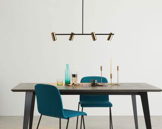 brass gold mid century modern spotlight style lighting over a dining table