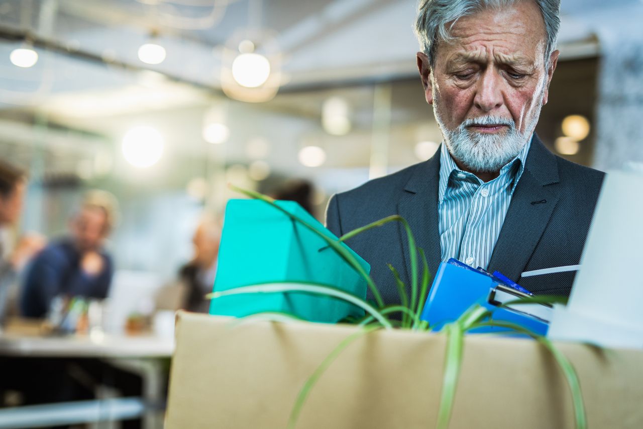 Mature businessman leaving his job carrying his belongings