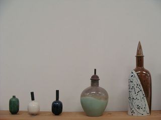 Archive ceramic vessels lined up on shelves at the Iittalla factory