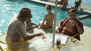 Frank John Hughes as Frank Sinatra sit at a poolside table in The Offer