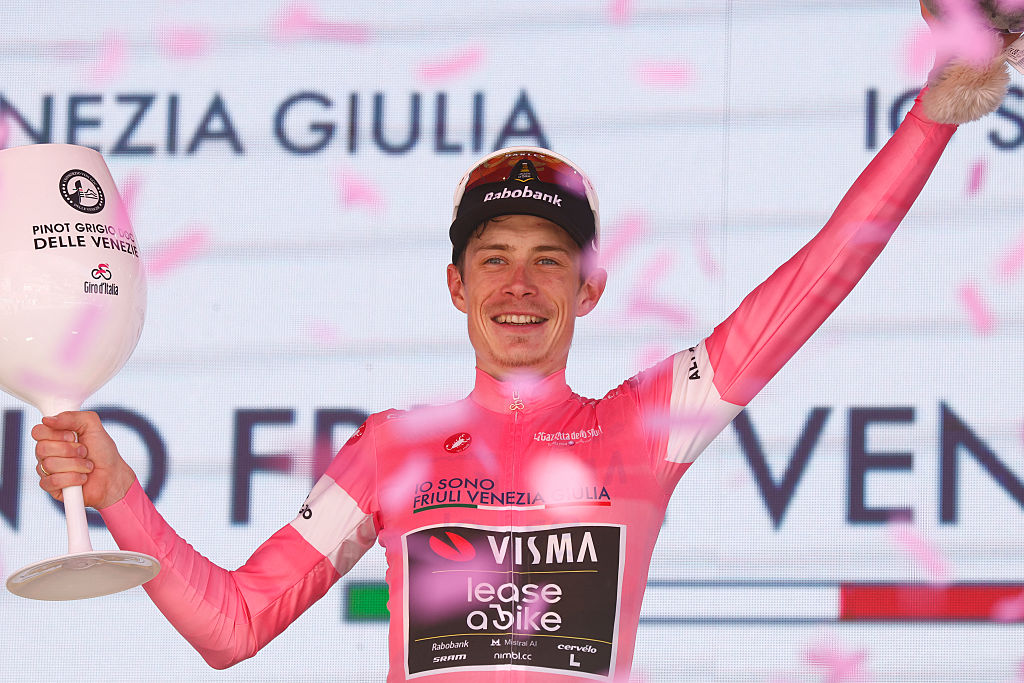 Jonas Vingegaard (Visma-Lease a Bike) celebrates the overall leader's pink jersey on the podium after winning the 14th stage of the Giro d'Italia 2026. (Photo by Luca Bettini / AFP via Getty Images)