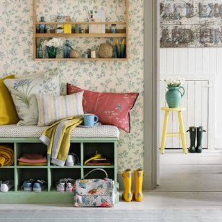 room with floral printed wall wooden shoe rack and wooden flooring