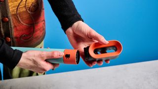 the dyson airwrap ID in teal and terracotta colorway (patina and orange) with a lapis case, with a brush, hairfryer, curling wand attachments