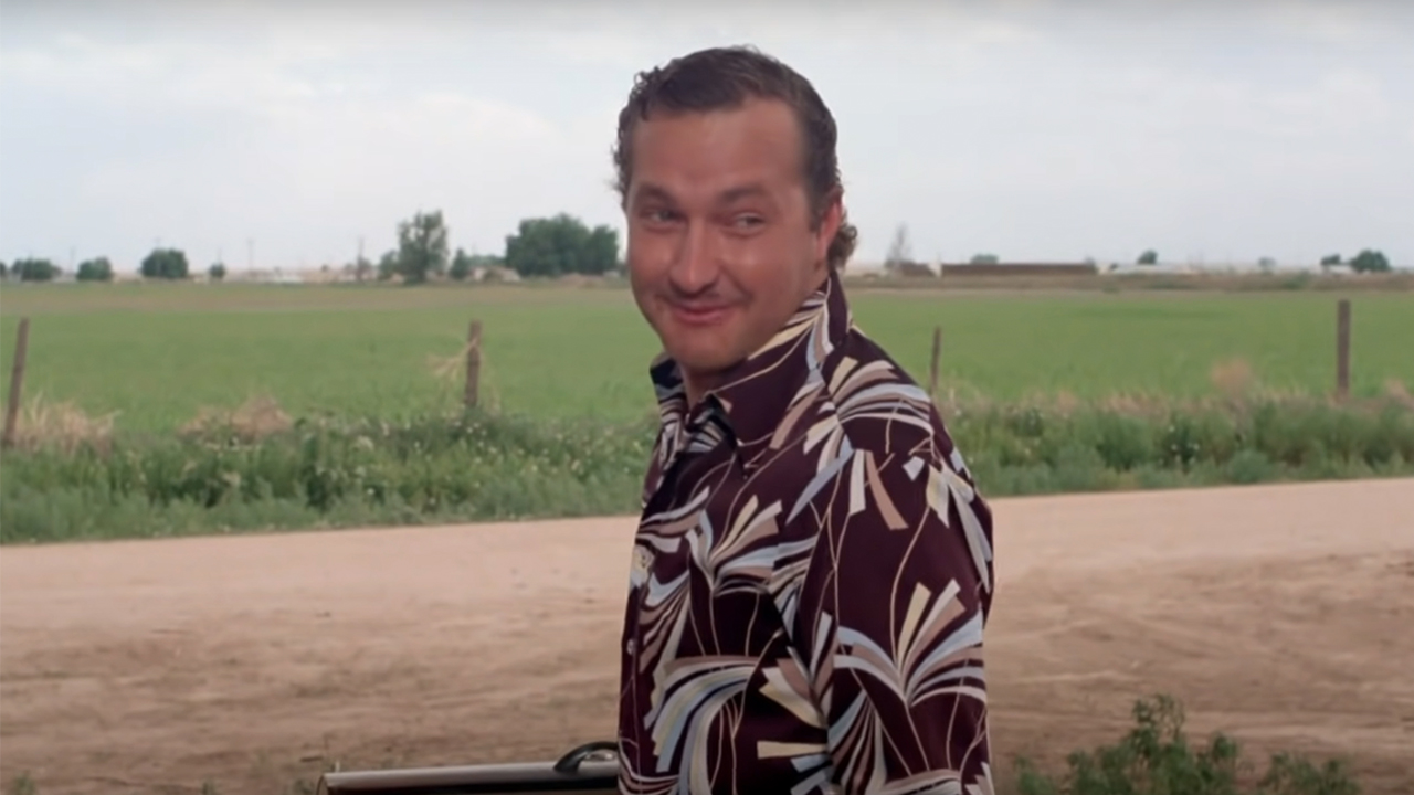 Randy Quaid as Eddie in Vacation, wearing a colorful shirt and looking over his shoulder