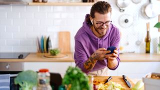 Smiling man in a kitchen preparing a vegan meal