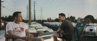 Ben Affleck and Jon Bernthal smiling sitting on top of a trailer in The Accountant 2