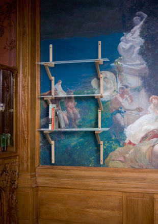 Shelving rack against painted wall