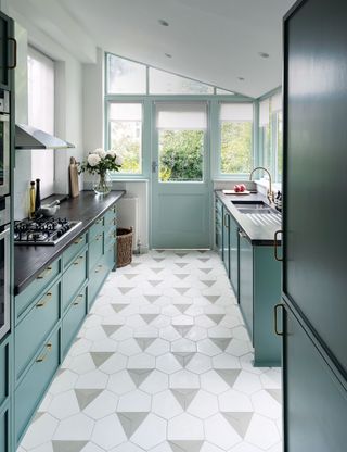 Small kitchen with hexagonal floor tiles and blue cabinets