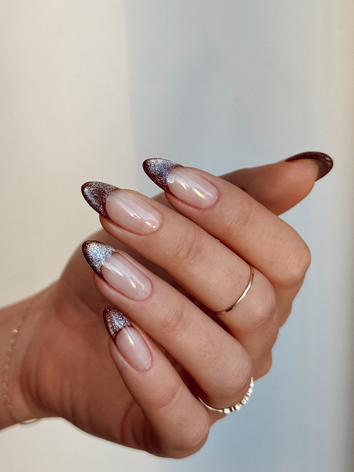 A brown, cat-eye French tip manicure