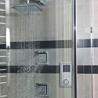 bathroom with shower and grey tiles
