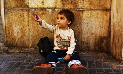 Cedra, a Syrian boy from the city of Homs, begs in a wealthy district of Beirut on November 16, 2013.